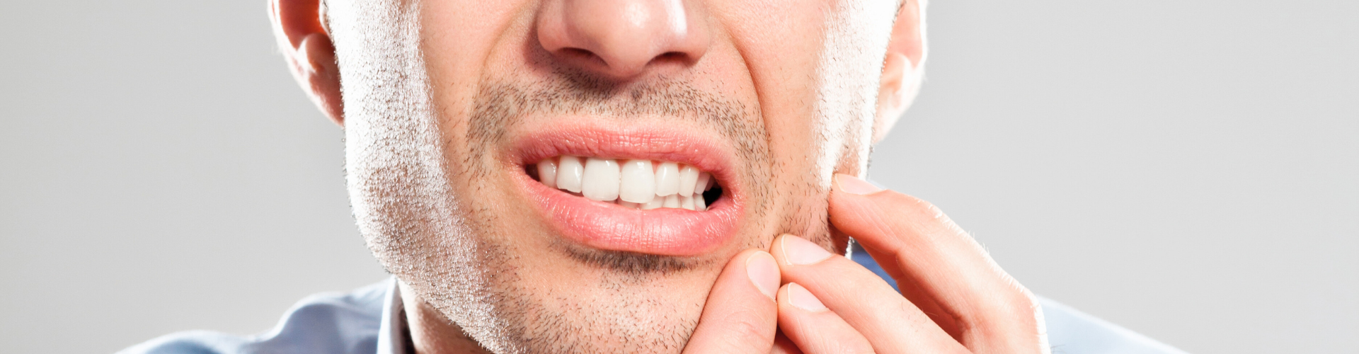 Man holding his cheek in pain.